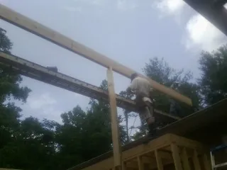 Carpenter setting a ridge beam over a new addition frame — Ice Dam Removal by Roofing Brothers in Papillion