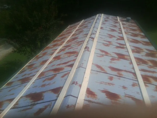 Rusted metal roof panels with new wood purlins before replacement — Storm Damage Roof Repair in Papillion by Roofing Brothers
