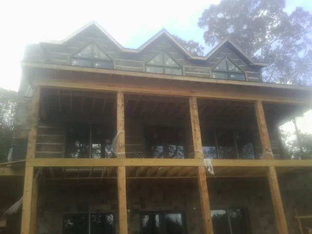 Dormers and porch framing on a large log home under construction — Roof Coating work by our crew in Papillion
