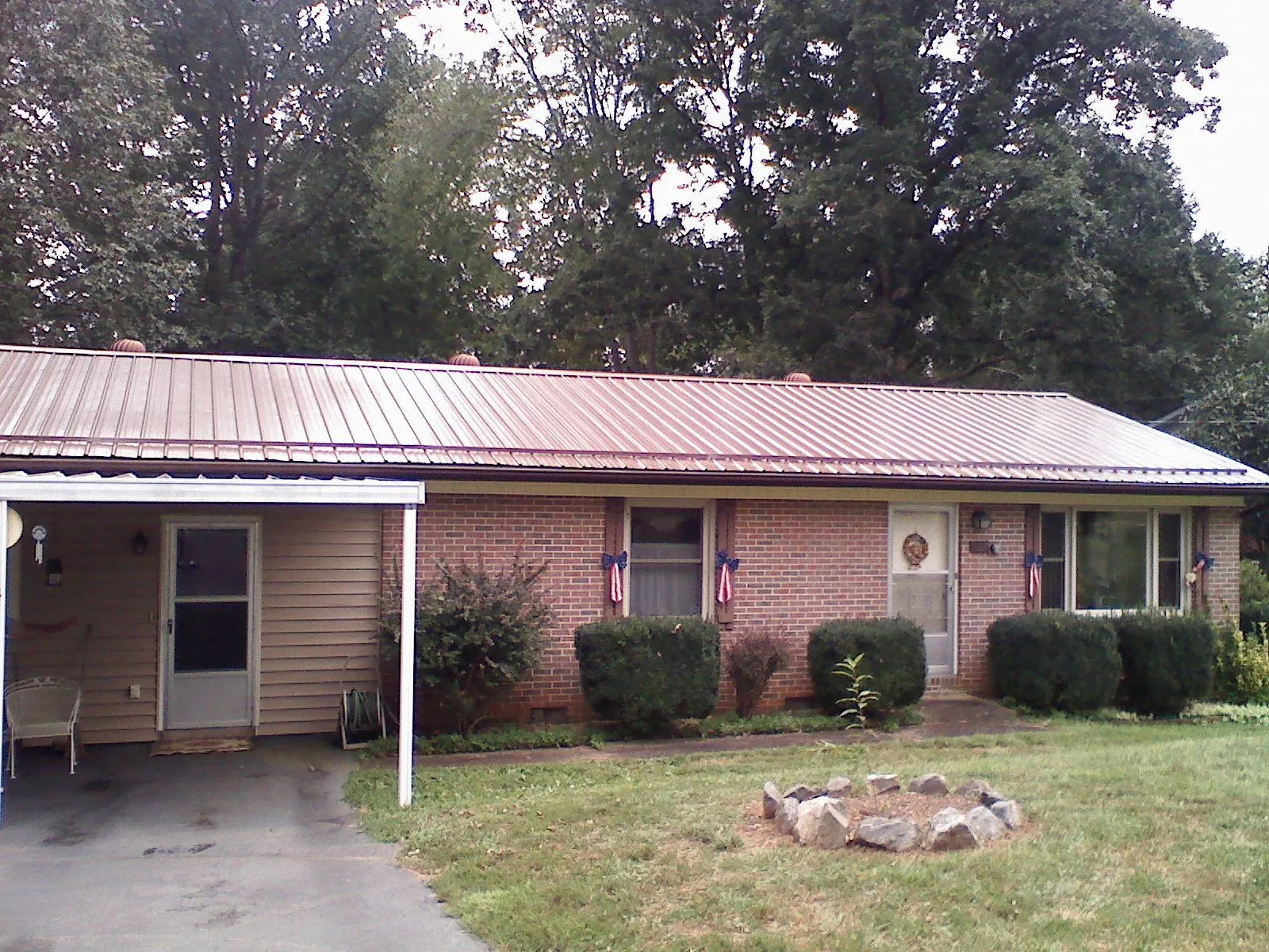 Bronze metal roof and carport on a brick ranch home — Roof Repair work by our crew in Papillion